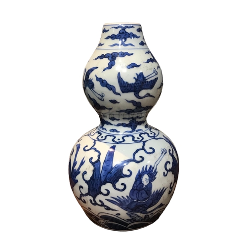 125 - A CHINESE BLUE AND WHITE HULUPING/DOUBLE GOURD VASE 
Decorated with cranes amongst clouds and seated... 