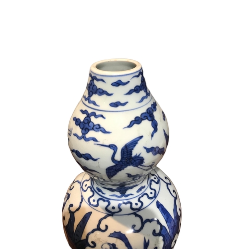 125 - A CHINESE BLUE AND WHITE HULUPING/DOUBLE GOURD VASE 
Decorated with cranes amongst clouds and seated... 