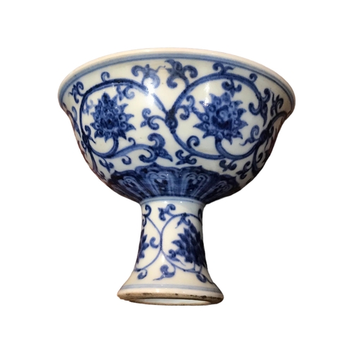 128 - A CHINESE BLUE AND WHITE STEM CUP 
Decorated with scrolling lotus flowers and vines, bearing a six c... 