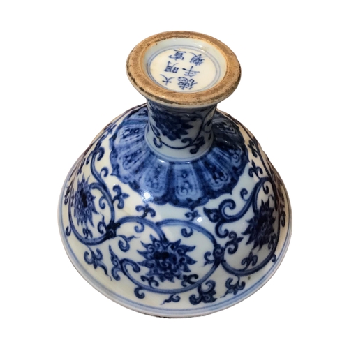 128 - A CHINESE BLUE AND WHITE STEM CUP 
Decorated with scrolling lotus flowers and vines, bearing a six c... 