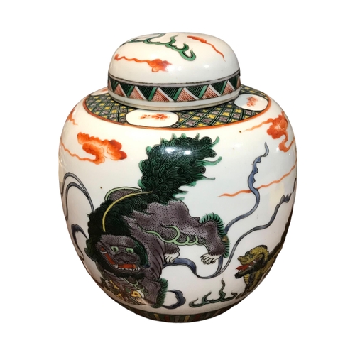 141 - A CHINESE FAMILLE VERTE GINGER JAR DECORATED WITH DOGS OF FO AMONGST CLOUDS. 
(h 14.6cm x diameter 1... 