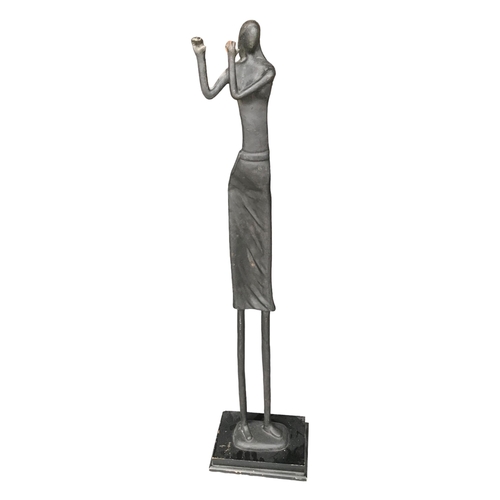 173 - AN EARLY 20TH CENTURY FLOOR STANDING ABSTRACT BRONZE SCULPTURE, A WOMAN PLAYING THE FLUTE.
(h 117.5c... 