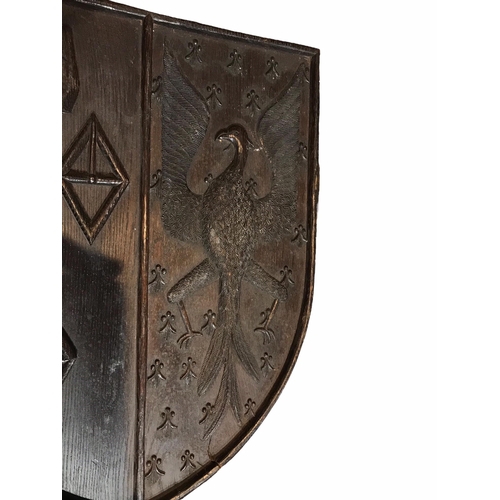 175 - AN 18TH CENTURY CARVED OAK SHIELD BEARING COAT OF ARMS
With an eagle facing left and three diamond s... 