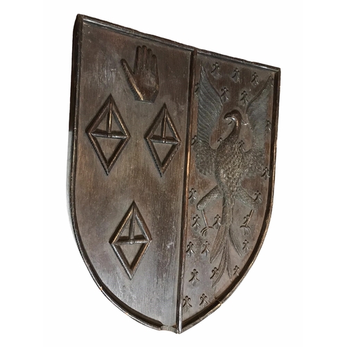 175 - AN 18TH CENTURY CARVED OAK SHIELD BEARING COAT OF ARMS
With an eagle facing left and three diamond s... 