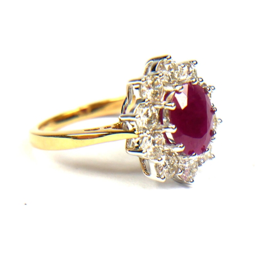 87B - AN 18CT YELLOW GOLD, OVAL RUBY AND DIAMOND CLUSTER RING. 
(Ruby 2.25ct. Diamonds 1.50ct)