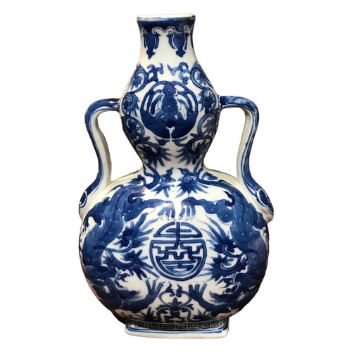 124 - A CHINESE BLUE AND WHITE BAOYUEPING MOON FLASK 
Decorated with two dragons encircling a Shou charact... 