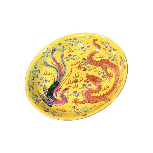 203 - A LATE 19TH/EARLY 20TH CENTURY CHINESE YELLOW GROUND FOOTED DISH
Decorated with a dragon and peacock... 