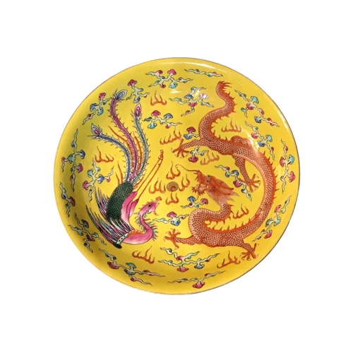 203 - A LATE 19TH/EARLY 20TH CENTURY CHINESE YELLOW GROUND FOOTED DISH
Decorated with a dragon and peacock... 