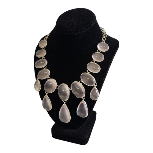 40A - A LARGE WHITE METAL AND ROSE QUARTZ NECKLACE
The arrangement of cabochon cut stones on pierced links... 