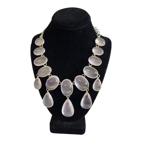 40A - A LARGE WHITE METAL AND ROSE QUARTZ NECKLACE
The arrangement of cabochon cut stones on pierced links... 