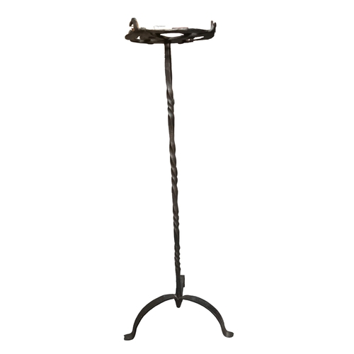 157A - A 16TH/17TH CENTURY WROUGHT IRON CANDLE STAND
Raised on candy twist supports and terminating on a tr... 