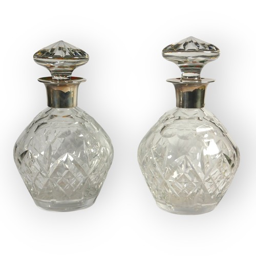 22 - GARRARD & CO. AND J.B. CHATTERLEY & SONS LTD, A NEAR PAIR OF SILVER TOPPED DECANTERS
Both hallmarked... 