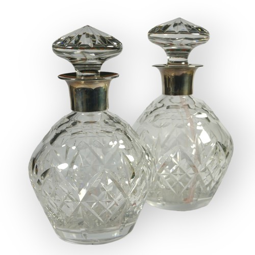 22 - GARRARD & CO. AND J.B. CHATTERLEY & SONS LTD, A NEAR PAIR OF SILVER TOPPED DECANTERS
Both hallmarked... 