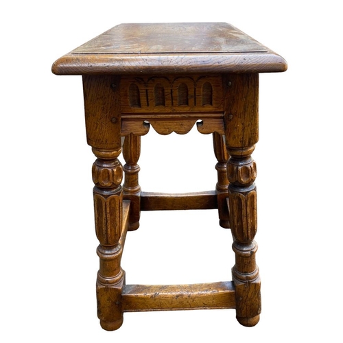 124 - A 17TH CENTURY DESIGN CARVED OAK JOINT STOOL.
(h 51cm x d 27cm x w 46.5cm)