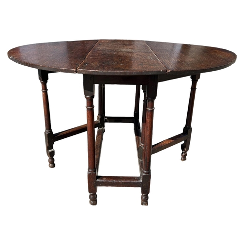 138 - A SMALL 17TH CENTURY WILLIAM AND MARY OAK GATELEG TABLE
The oval top support on eight turned gun bar... 