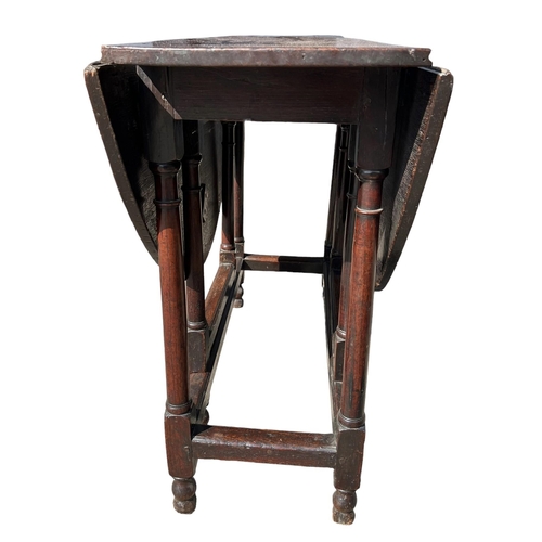 138 - A SMALL 17TH CENTURY WILLIAM AND MARY OAK GATELEG TABLE
The oval top support on eight turned gun bar... 