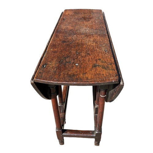 138 - A SMALL 17TH CENTURY WILLIAM AND MARY OAK GATELEG TABLE
The oval top support on eight turned gun bar... 