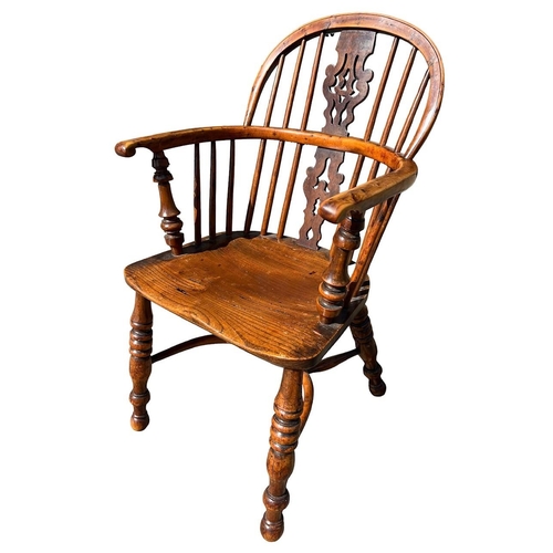 142 - A 19TH CENTURY YEW WOOD AND ELM WINDSOR CHAIR
The pierced splat and turned spindles above solid shap... 