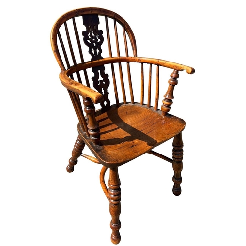 142 - A 19TH CENTURY YEW WOOD AND ELM WINDSOR CHAIR
The pierced splat and turned spindles above solid shap... 