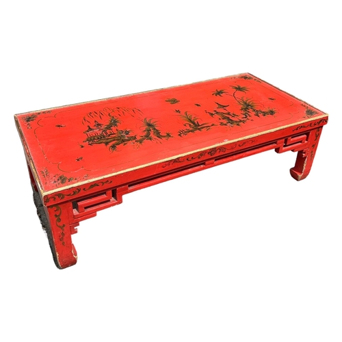 145 - A 20TH CENTURY RED LACQUERED CHINESE CHINOISERIE DECORATED LOW COFFEE TABLE.