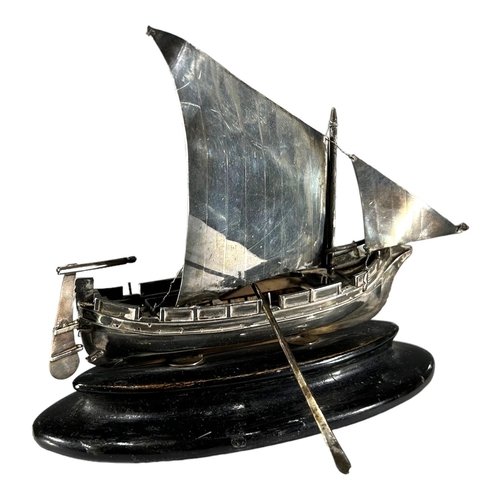 26 - A MID 20TH CENTURY MALTESE SILVER MODEL OF A BOAT 
On an ebonised stand, having two rowing oars. 
(h... 