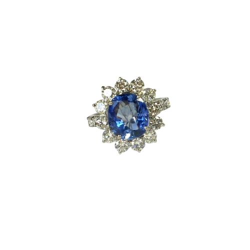 35 - AN 18CT WHITE GOLD, ROUND CUSHION CUT SAPPHIRE AND ROUND BRILLIANT CUT DIAMOND CLUSTER RING, flanked... 