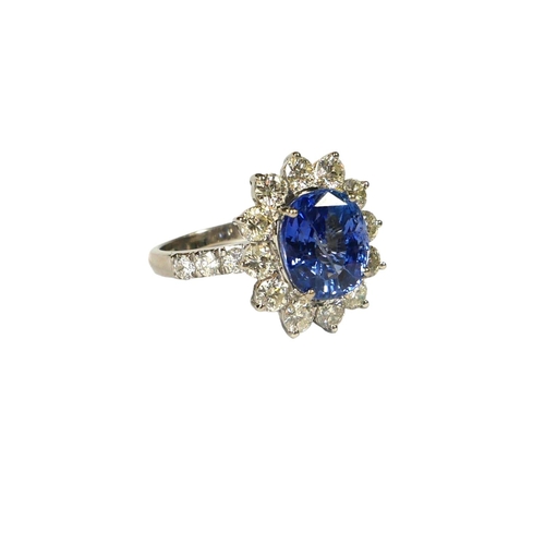 35 - AN 18CT WHITE GOLD, ROUND CUSHION CUT SAPPHIRE AND ROUND BRILLIANT CUT DIAMOND CLUSTER RING, flanked... 