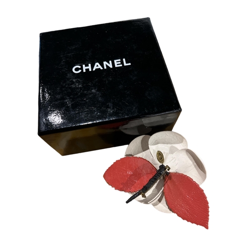 101A - CHANEL, A CREAM AND RED STYLISED FLOWER HEAD BROOCH
In original box.