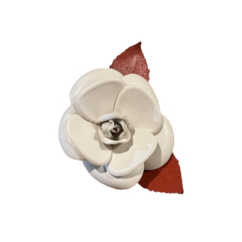 101A - CHANEL, A CREAM AND RED STYLISED FLOWER HEAD BROOCH
In original box.