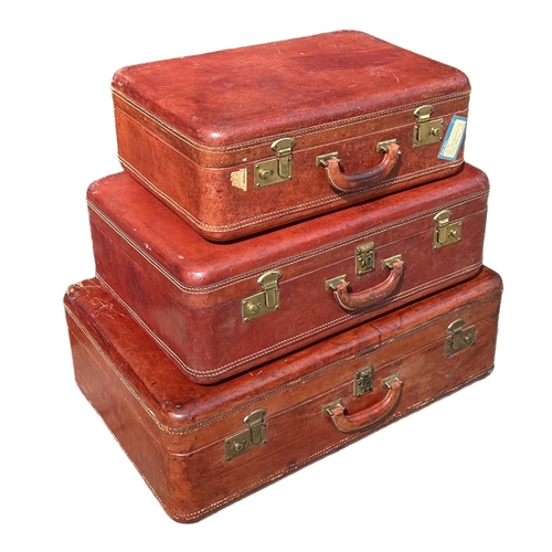 164 - A SET OF THREE GRADUATED MATCHING TAN LEATHER SUITCASES. 
(largest 75cm x 48cm x 23.5cm, medium 63cm... 