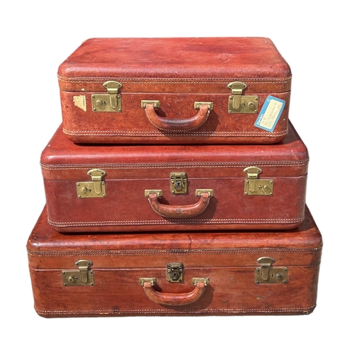 164 - A SET OF THREE GRADUATED MATCHING TAN LEATHER SUITCASES. 
(largest 75cm x 48cm x 23.5cm, medium 63cm... 
