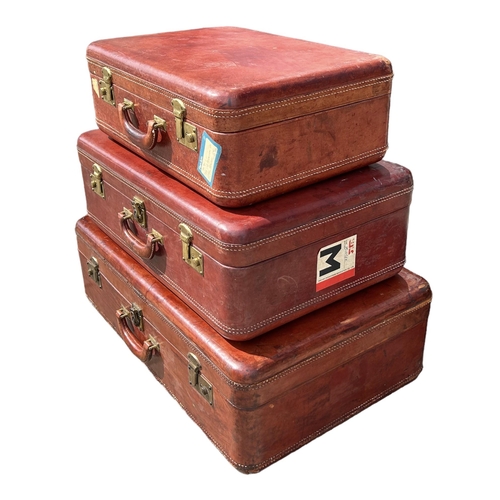 164 - A SET OF THREE GRADUATED MATCHING TAN LEATHER SUITCASES. 
(largest 75cm x 48cm x 23.5cm, medium 63cm... 