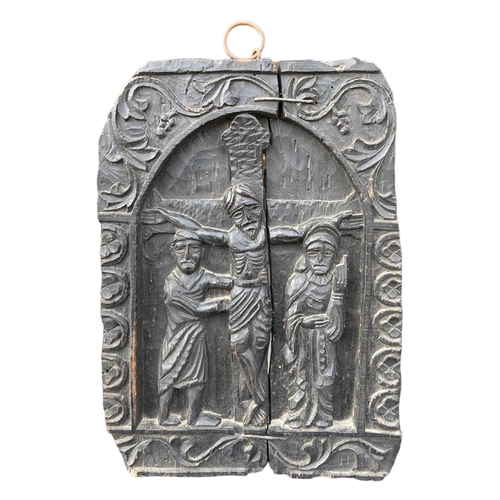 163 - A 19TH CENTURY CARVED BLACK OAK CARVED PANEL DEPICTING THE CRUCIFIXION IN DEEP RELIEF. 
(41.5cm x 29... 