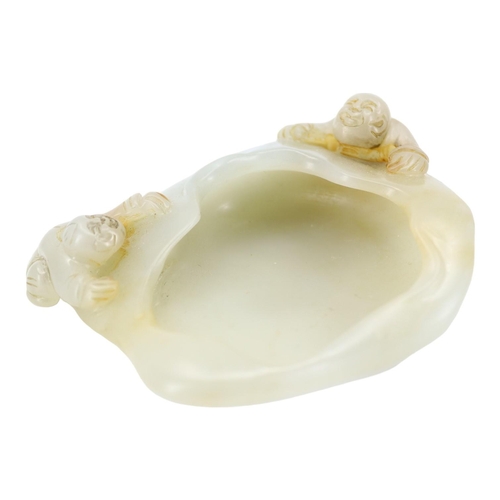 122 - A CHINESE GREENISH-WHITE JADE ‘PEACH & BOYS’ BRUSH WASHER CARVING
Two boys climbing to mouth rim, on... 