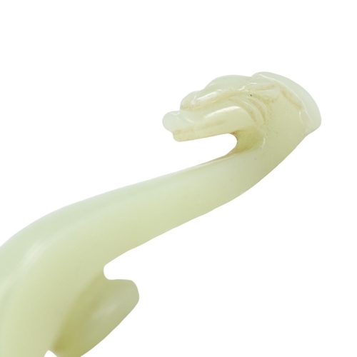 131 - A CHINESE PALE GREEN JADE DRAGON OR PHOENIX HEAD BELT HOOK. 
(length 7.7cm)