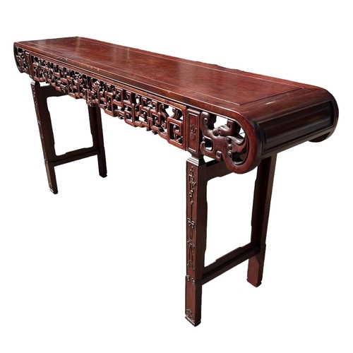 218 - A LARGE CHINESE HARDWOOD ALTAR TABLE
The plank top above a carved and priced frieze and scrolling dr... 