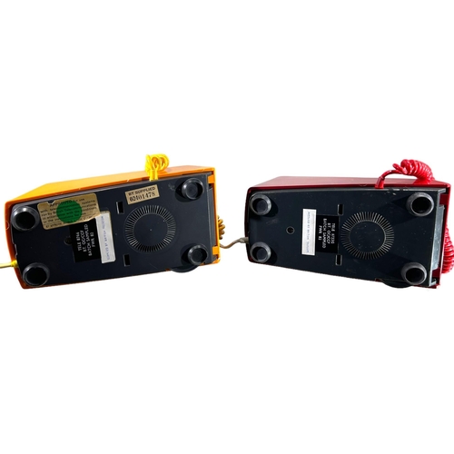 207 - TWO 1970’S/80’S RED AND ORANGE TRIMPHONES, two toned, punch button and dial. 
H-11.2cm x W-11cm x D-... 