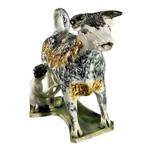 51 - LATE 18TH/ EARLY 19TH CENTURY STAFFORDSHIRE/ YORKSHIRE PEARLWARE COW CREAMER AND MILKMAID
Sponge dec... 