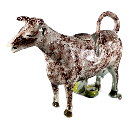 52 - LATE 18TH/ EARLY 19TH CENTURY STAFFORDSHIRE/ YORKSHIRE PEARLWARE COW CREAMER AND MILKMAID
Sponge dec... 