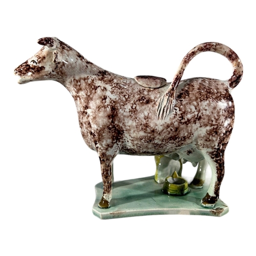 52 - LATE 18TH/ EARLY 19TH CENTURY STAFFORDSHIRE/ YORKSHIRE PEARLWARE COW CREAMER AND MILKMAID
Sponge dec... 