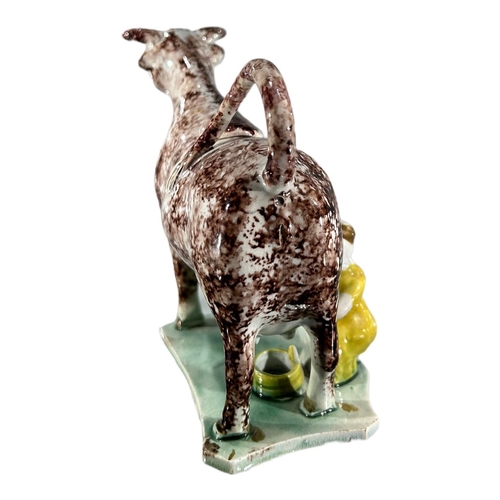 52 - LATE 18TH/ EARLY 19TH CENTURY STAFFORDSHIRE/ YORKSHIRE PEARLWARE COW CREAMER AND MILKMAID
Sponge dec... 