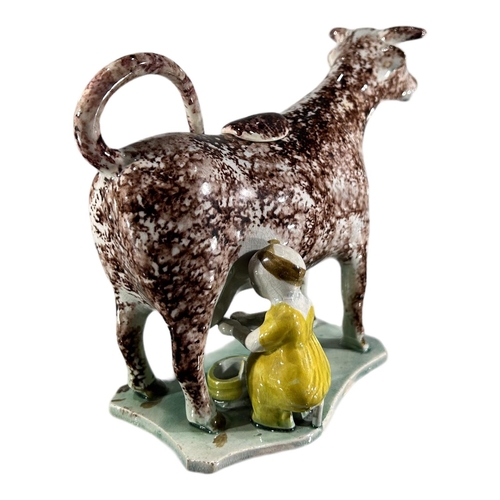 52 - LATE 18TH/ EARLY 19TH CENTURY STAFFORDSHIRE/ YORKSHIRE PEARLWARE COW CREAMER AND MILKMAID
Sponge dec... 