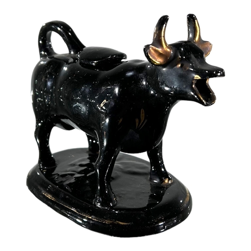 53 - A VICTORIAN JACKFIELD BLACK AND GOLD COW CREAMER. TOGETHER WITH DELFT BLUE AND WHITE COW CREAMER. 
(... 