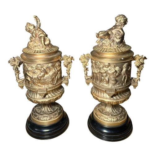 184A - A PAIR OF FRENCH REGENCY DESIGN GILDED BRONZE LIDDED URNSDecorated with Neoclassical scenes, putti f... 