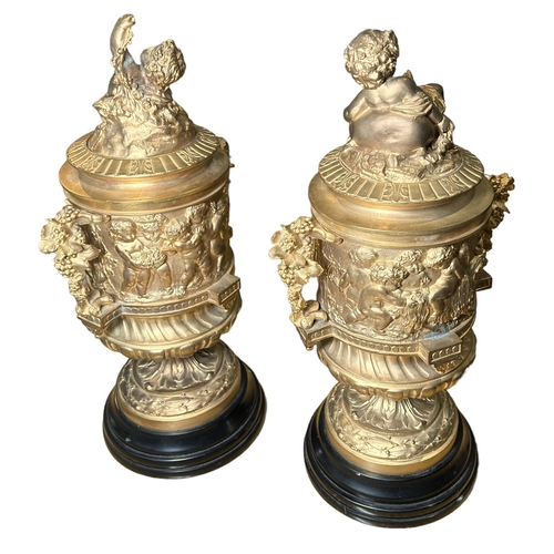 184A - A PAIR OF FRENCH REGENCY DESIGN GILDED BRONZE LIDDED URNSDecorated with Neoclassical scenes, putti f... 