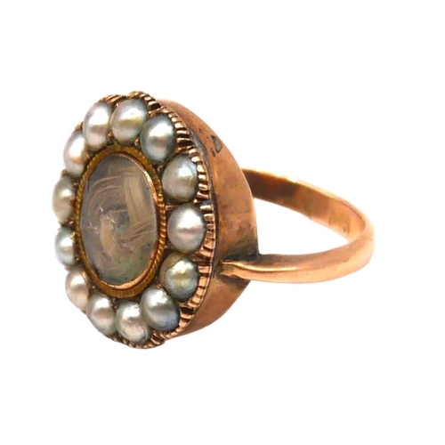 23 - A LATE GEORGIAN/EARLY VICTORIAN 9CT GOLD AND PEARL MEMENTO MORI MOURNING RING
Having central woven s... 