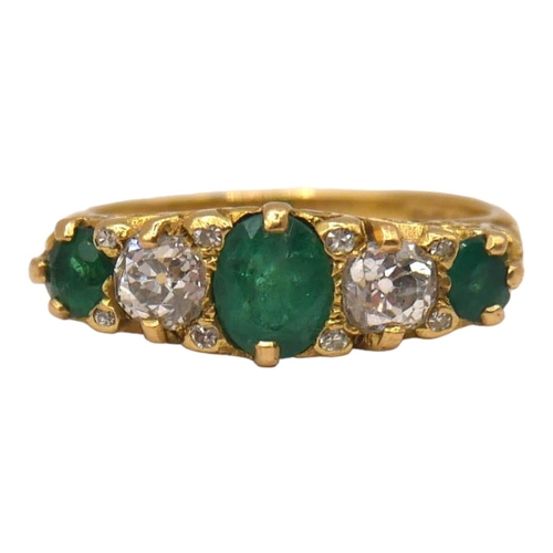 29 - A VINTAGE 18CT YELLOW GOLD, FIVE STONE DIAMOND & EMERALD RING
The central oval cut emerald (approx. ... 