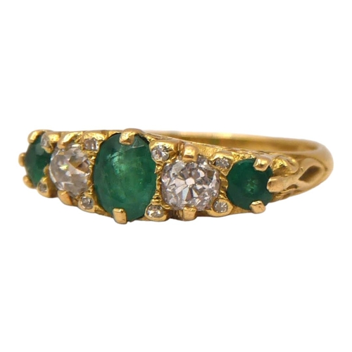 29 - A VINTAGE 18CT YELLOW GOLD, FIVE STONE DIAMOND & EMERALD RING
The central oval cut emerald (approx. ... 