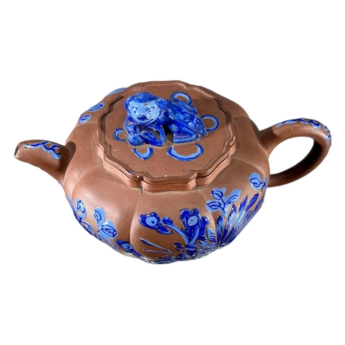 144 - A CHINESE YIXING CLAY TEAPOT WITH BLUE ENAMELLED DECORATIONShowing blue floral decoration and Dog of... 