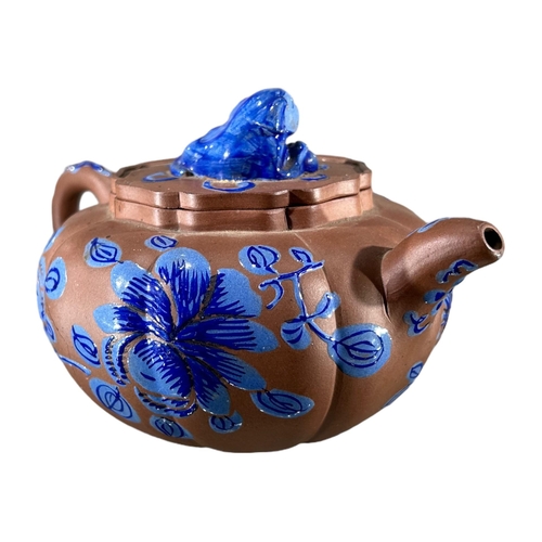 144 - A CHINESE YIXING CLAY TEAPOT WITH BLUE ENAMELLED DECORATIONShowing blue floral decoration and Dog of... 